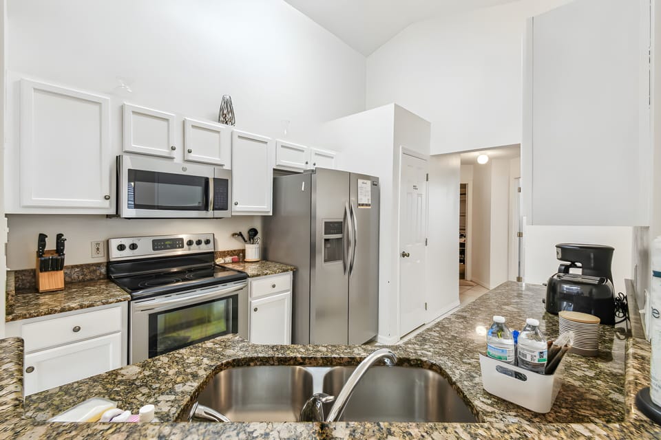 Discover a stunning kitchen with rich granite countertops and bright white cabinetry, blending style and functionality. Equipped with modern appliances and plenty of storage, this space inspires your culinary creativity.
