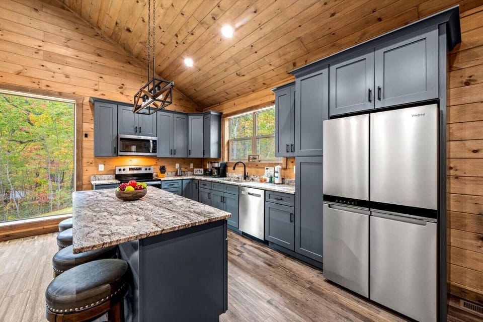 The kitchen is equipped with new cabinets and a full suite of stainless steel appliances.