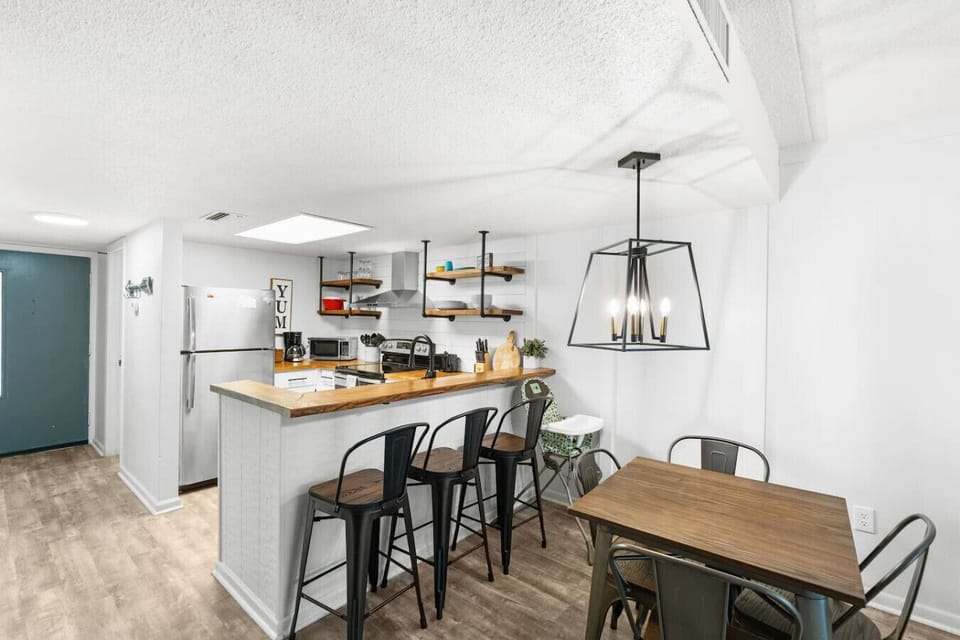 The dining table is located just off the kitchen. There is additional bar seating.