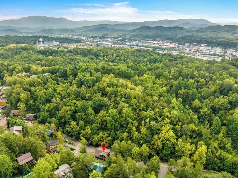Relax in a spacious bedroom featuring a king-size bed, private bathroom, and closet. Step onto the deck for fresh air and nature views. With cozy cabin décor and modern amenities, this inviting retreat offers perfect blend of comfort and tranquility.