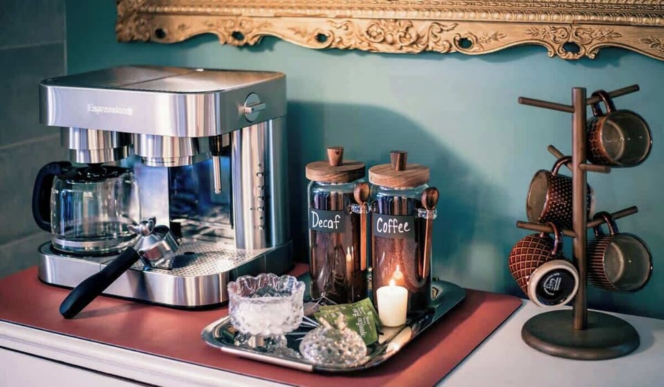 Curated coffee and espresso station with a premium machine, stylish mugs, and inviting details—an ideal morning ritual spot in this renovated Uptown Charlotte mid-term rental.