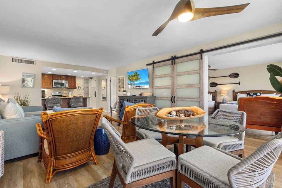 Settle into your open-concept living space where coastal charm meets modern comfort, featuring stylish furnishings, a fully-equipped kitchen, and barn doors leading to your private bedroom retreat.