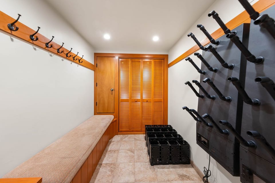 Your gear stays organized in this ski-equipped mudroom featuring wall-mounted racks, built-in bench seating, and convenient boot storage for seamless après-ski transitions.