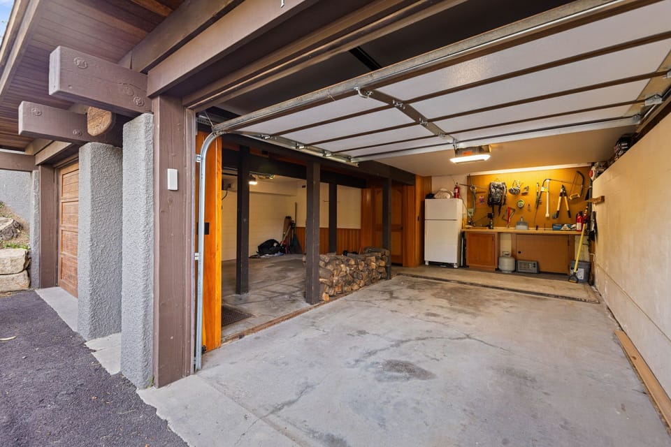 A functional garage with storage and workspace provides practical amenities during your stay, including organized shelving and tools for any needs you might have.