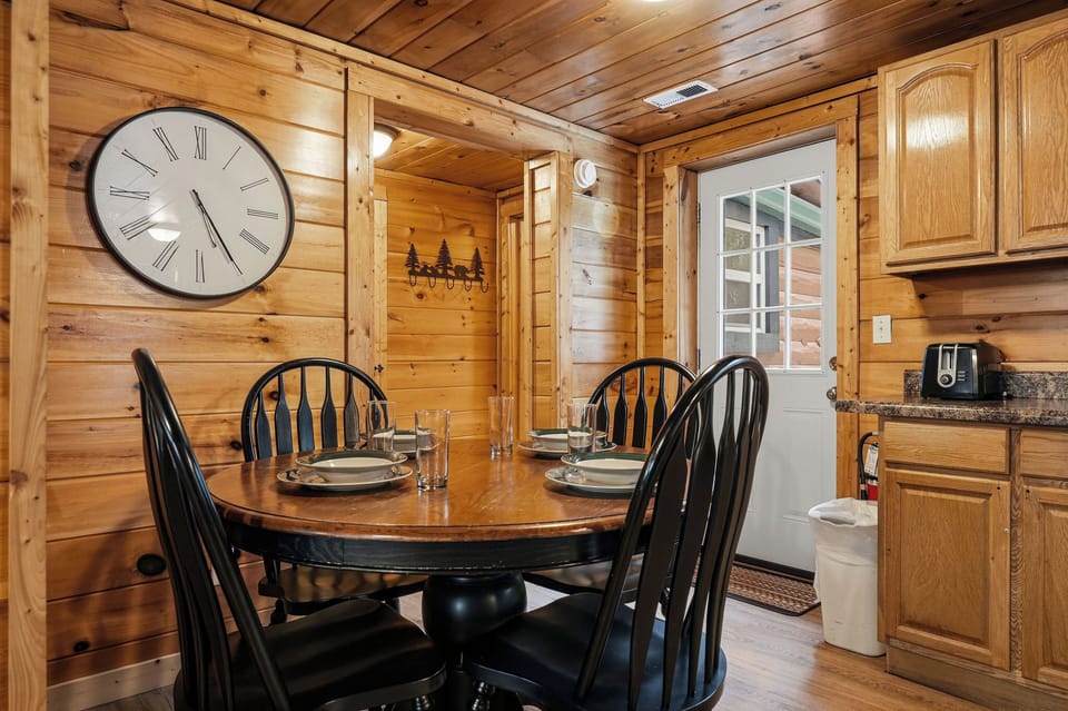 Gather around your rustic dining table where warm wood walls create an inviting atmosphere for memorable meals together.