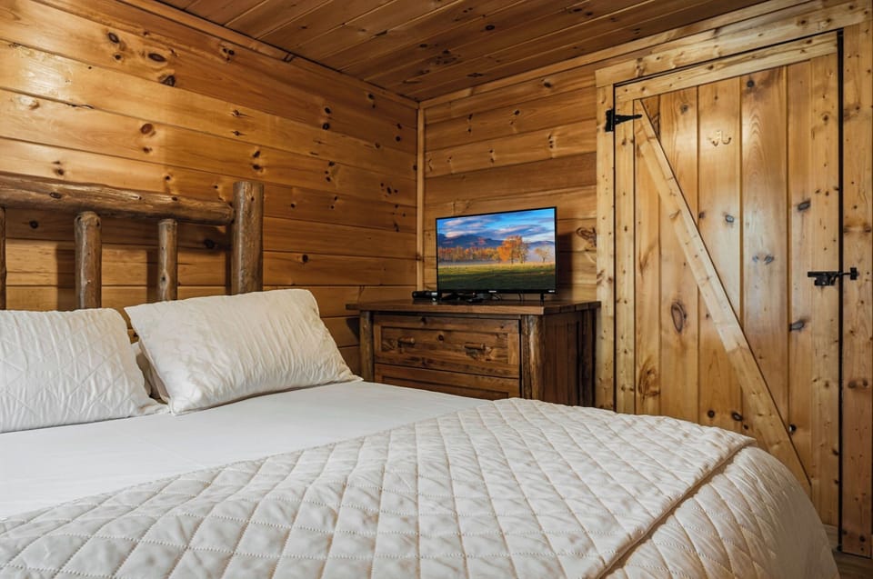 Wrap yourself in rustic luxury with warm wood walls, crisp linens, and your own TV for cozy mountain evenings.