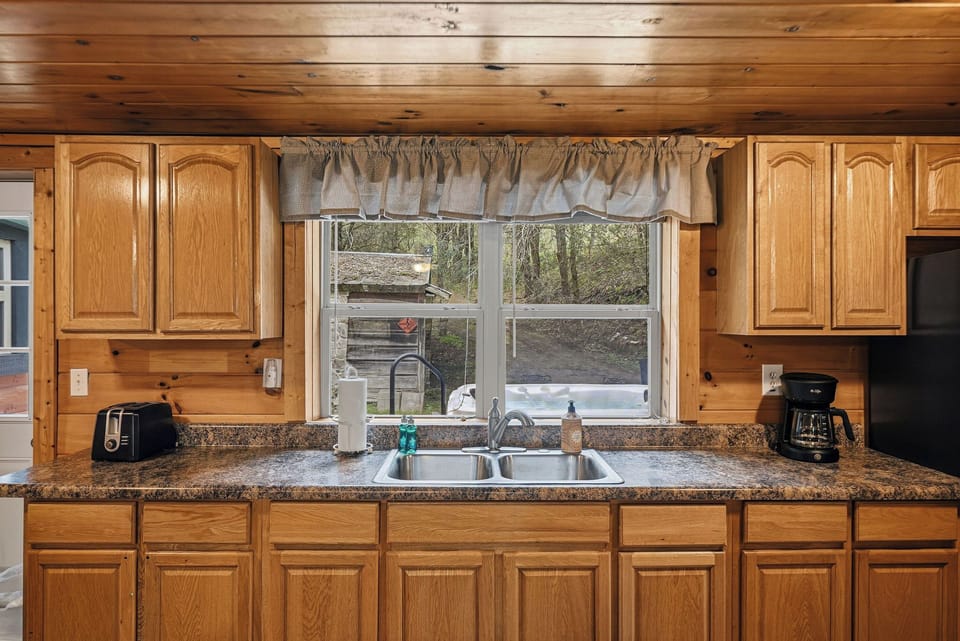 Cook your favorite meals in this warm rustic kitchen with granite counters, rich wood cabinets, and peaceful garden views.