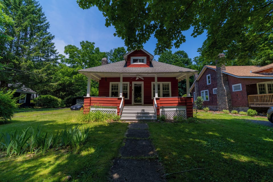 front yard and front porch surrounded by mature trees 