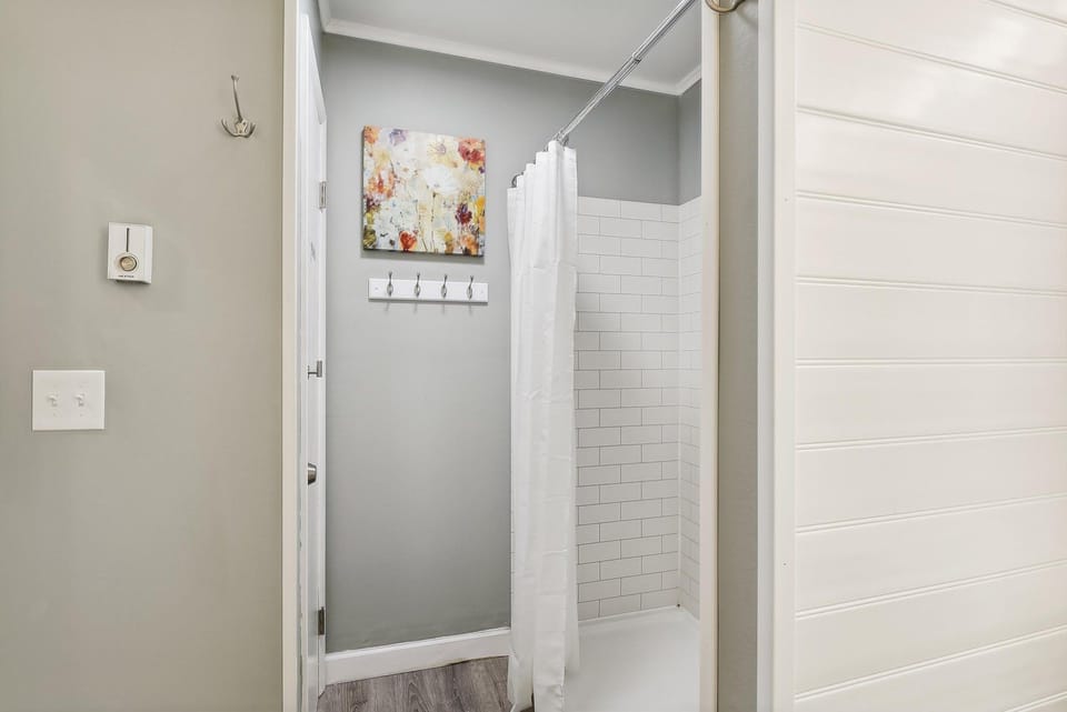 Step into your private sanctuary with a spotless walk-in shower and classic subway tiling. Fresh linens await you on convenient wall hooks, making every refresh effortless.
