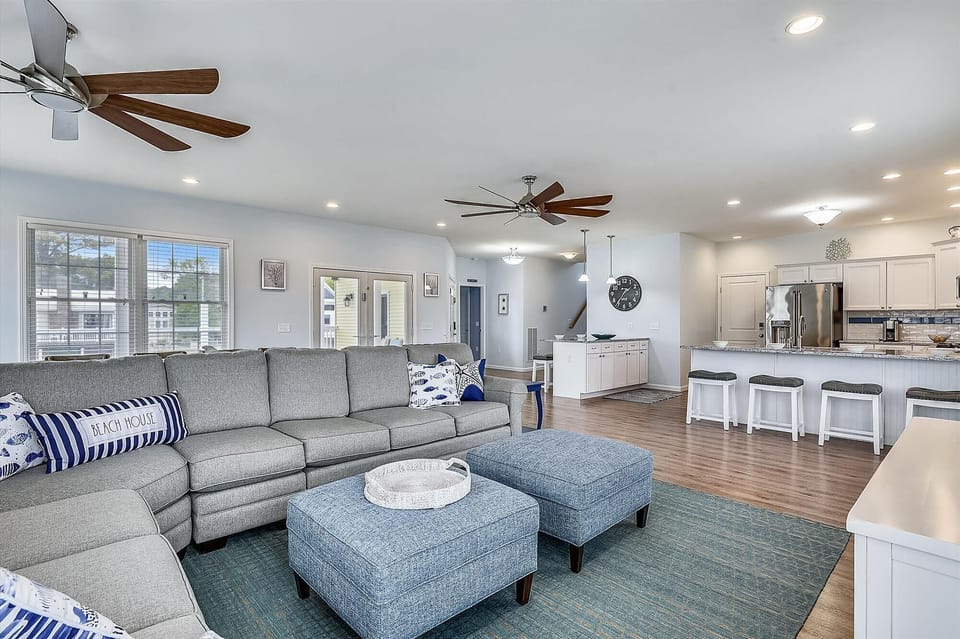 Relax in your spacious open-concept living area, where coastal-inspired comfort meets modern convenience. Plush seating, ceiling fans, and a fully equipped kitchen create the perfect space for gathering with loved ones.