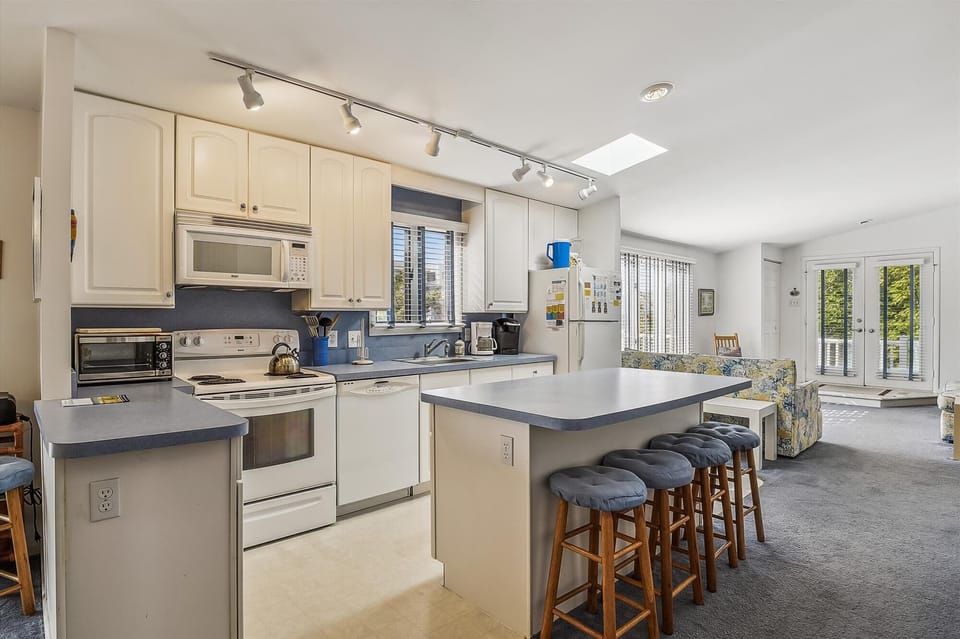 Your spacious kitchen and living area blend comfort and function, with natural light pouring through skylights and doors that open to your private outdoor space.