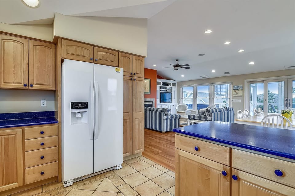 Enjoy your home-away-from-home in this spacious kitchen with rich wood cabinetry, modern appliances, and open views to the bright living area and sunny windows beyond.