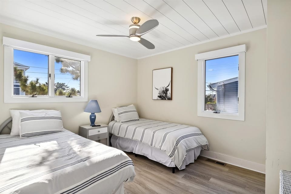 Drift off in this bright, airy bedroom with two cozy twin beds, crisp linens, and a gentle ceiling fan to keep your dreams cool and comfortable.