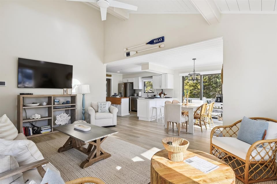 Relax in your bright open-concept living space where coastal elegance meets comfort. Sunlight pours through large windows as you unwind in the airy living room or gather at the dining table.