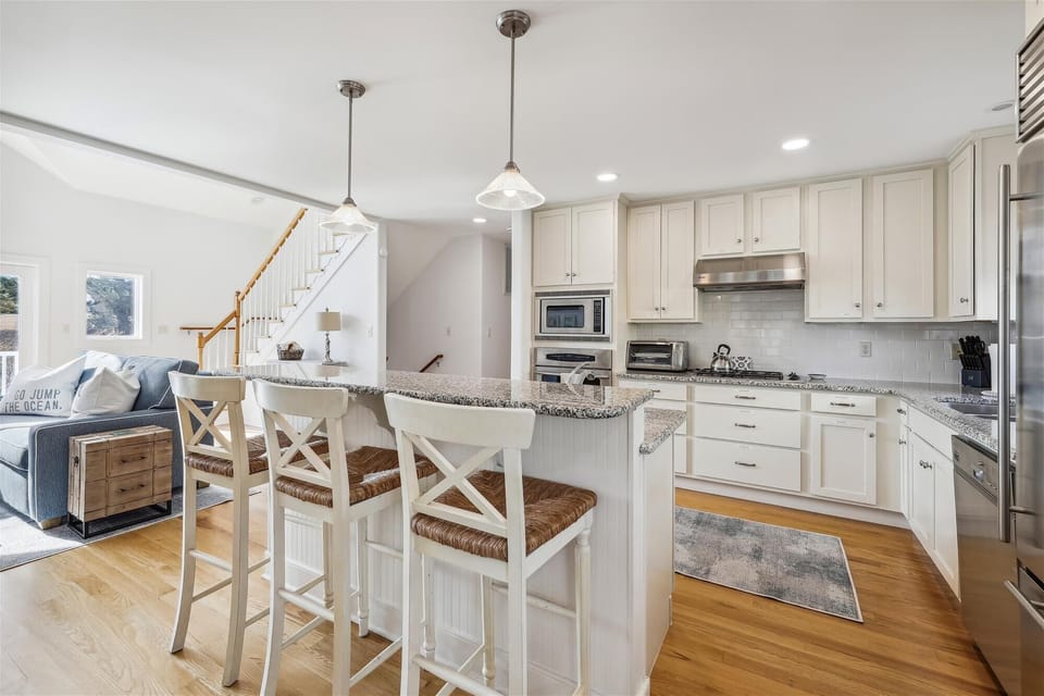 Picture yourself preparing meals in this bright, coastal-inspired kitchen with granite countertops, stainless appliances, and a breakfast island perfect for morning coffee or evening conversations.