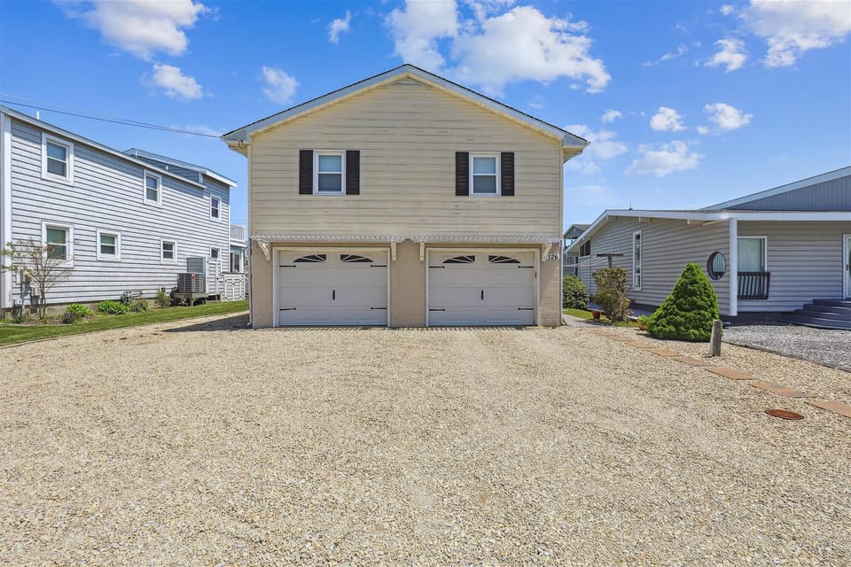 This two-story vacation rental features ample parking with a two-car garage and spacious gravel driveway, all in a friendly residential neighborhood with easy beach access.