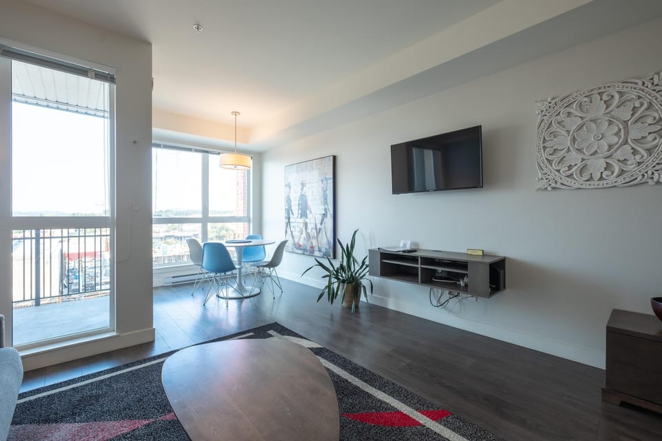 Wide-angle living room view featuring a wall-mounted console, Smart TV area, and generous natural window light.