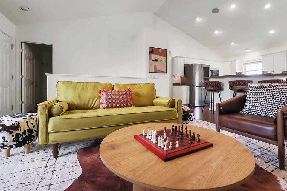 Plush seats in the living room with a chess game on the center table