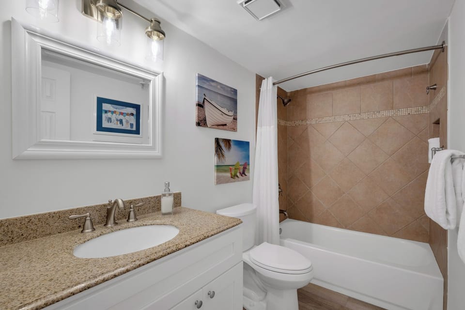 Ensuite master bathroom with a tub/shower combo and white, fresh spa towels