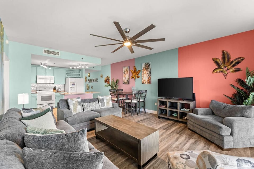 Open-Concept Living Area with Sleeper Sofa, Private Balcony Access, Custom Mural, TV and Lake Views