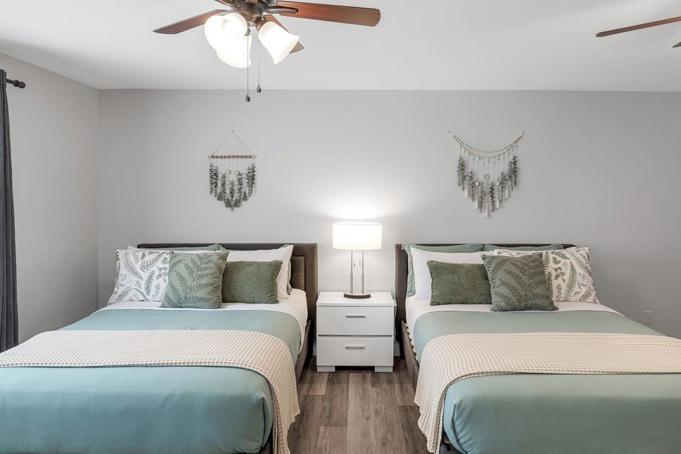 Master bedroom with 2 queen beds, TV, workspace, and a spacious walk-in closet.