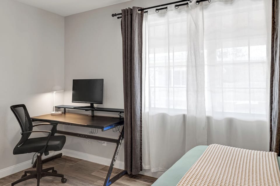 Master bedroom with 2 queen beds, TV, workspace, and a spacious walk-in closet.