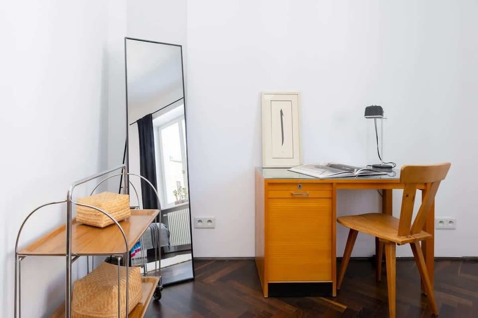 A cozy bedroom with a vanity and mirror offers restful sleep and a handy workspace.