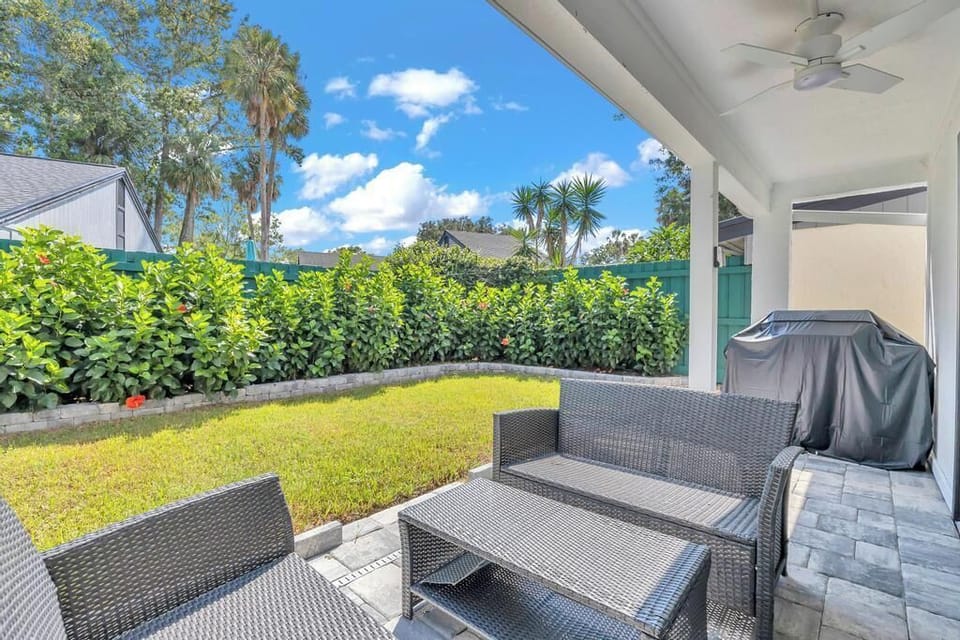 - Grill up something tasty or kick back under the ceiling fan in this covered patio lounge
- Wicker seating and greenery provide the ideal space for relaxing outdoors
- Fully fenced and private with a grassy yard for added comfort