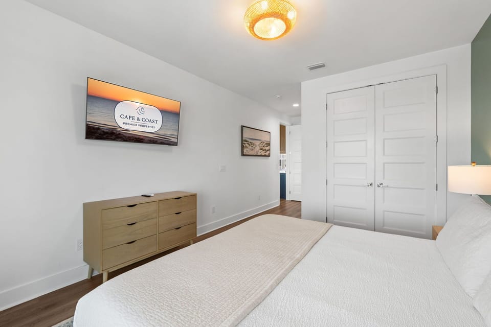 Your peaceful retreat awaits with a plush bed, ample storage in the mid-century dresser, and a warm woven light fixture overhead. Closet space keeps everything tidy during your stay.