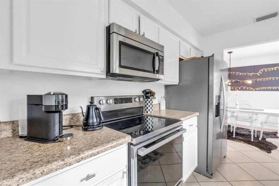 Kitchen: Sleek appliances and modern decor invite culinary adventures in sunny Naples!