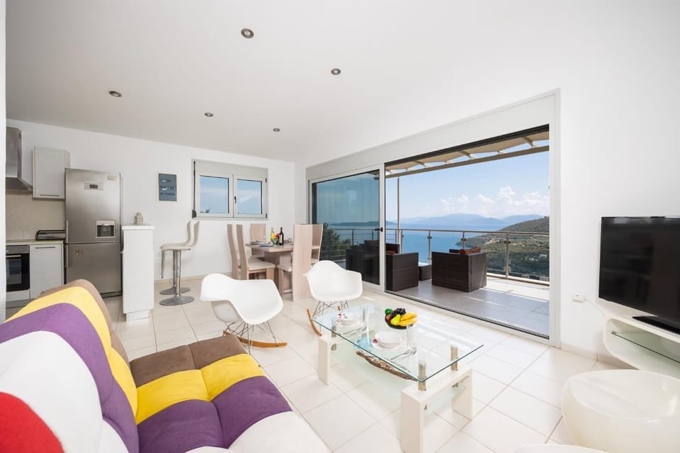 Open-plan living room with sofa, dining area, kitchen, A/C, WiFi internet, and satellite TV