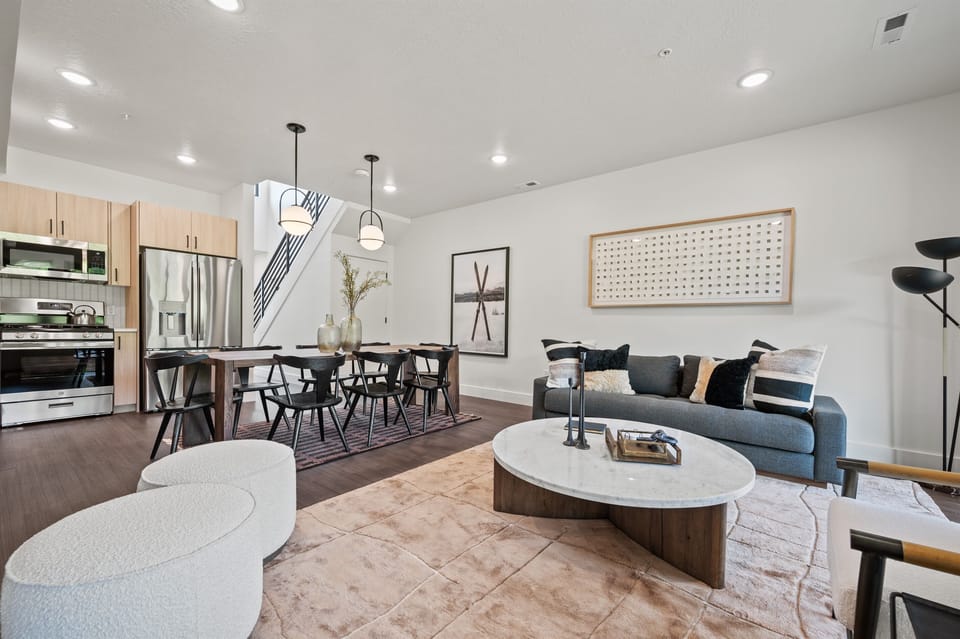 The living room features a comfortable sofa with plush pillows, complemented by modern decor.