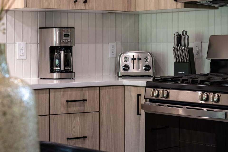 Featuring state-of-the-art appliances, including a Cuisinart coffee maker, a brand new toaster, and a gas stove.