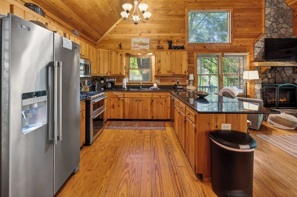 Rustic kitchen with modern appliances and cozy cabin ambiance.