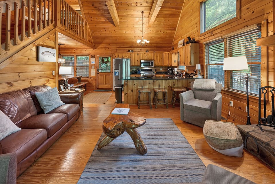 Rustic open-concept living area with cozy seating and a fully equipped kitchen.