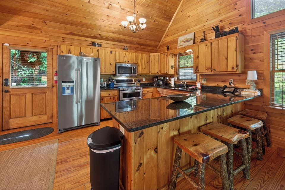 Rustic kitchen with granite countertops and stainless steel appliances, perfect for cozy cabin meals.
