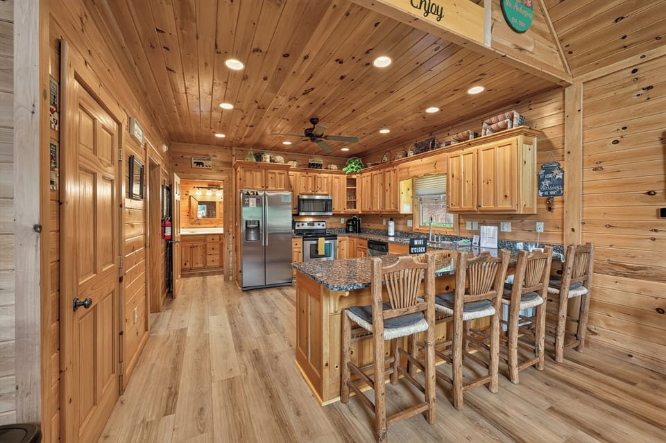 Rustic kitchen with granite countertops and breakfast bar seating for five.