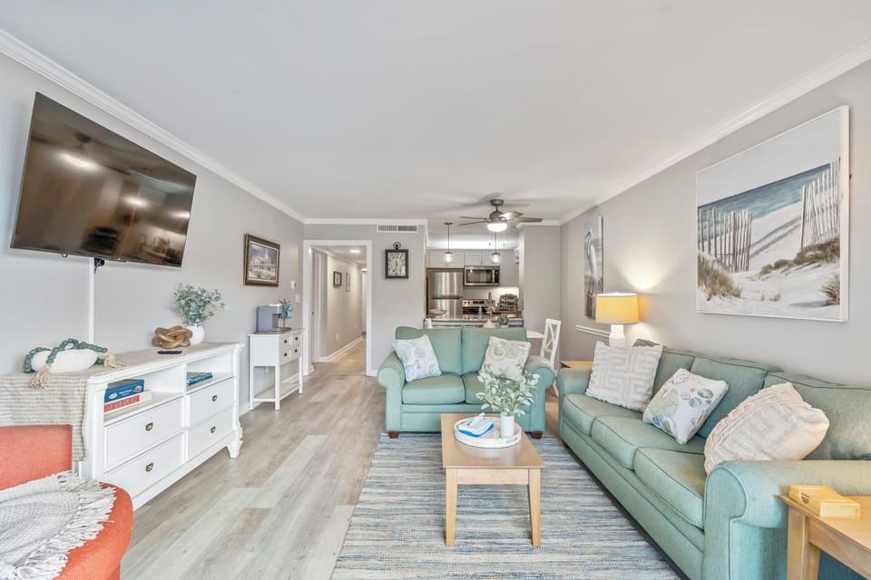 A bright and inviting living room with cozy seating and a TV for comfort.