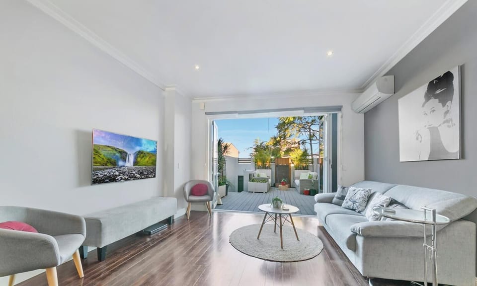 A bright and airy open-plan living area with elegant wood flooring.