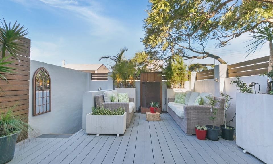 A peaceful outdoor deck area equipped with comfortable wicker seating.