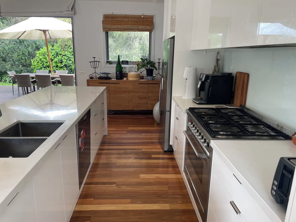Galley kitchen with view out to southern terrace with exterior dining table.
