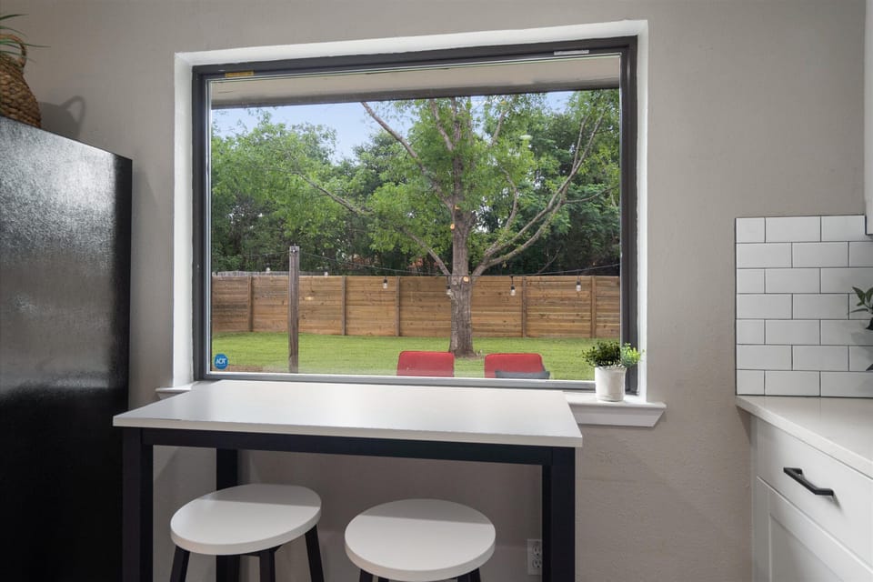 Kitchen island and stools looking into enclosed back yard 
