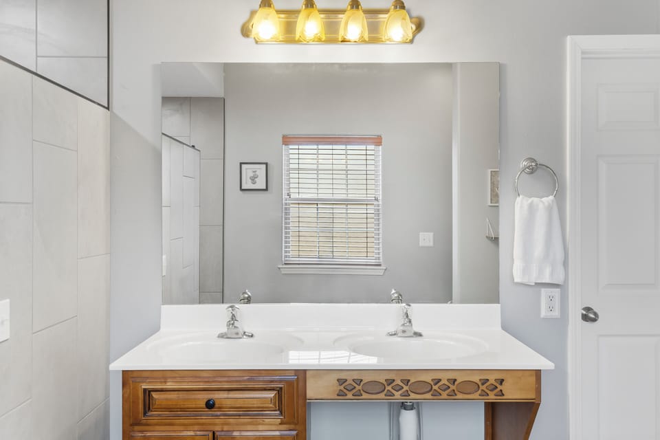 En-suite bathroom with dual sinks, and walk-in shower