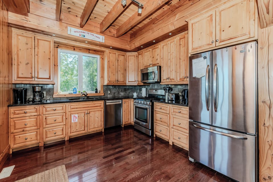 Cook in style with stainless steel appliances and handcrafted cabinetry in a fully stocked kitchen—perfect for hosting lakeside feasts.
