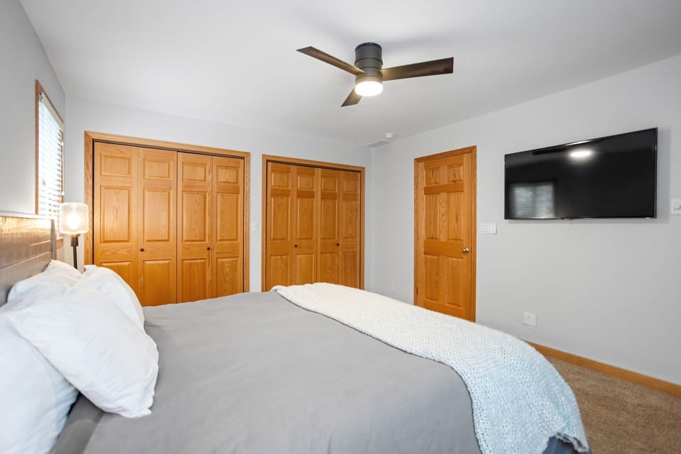 Primary bedroom with TV and ample closet space.