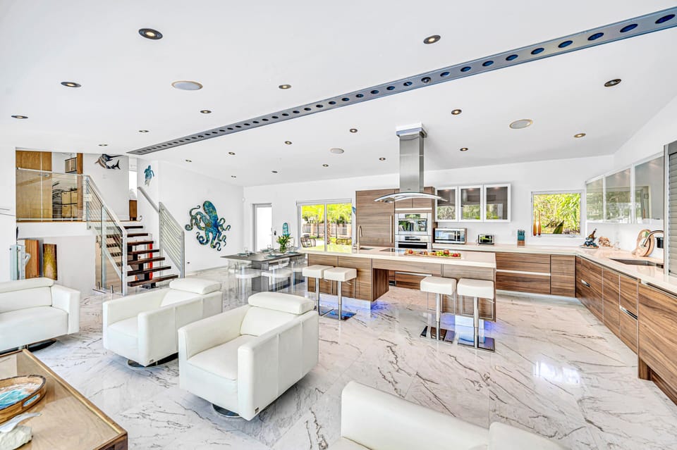 The open-concept living, dining, and chef's kitchen offers an inviting space for guests to gather and enjoy at ease.