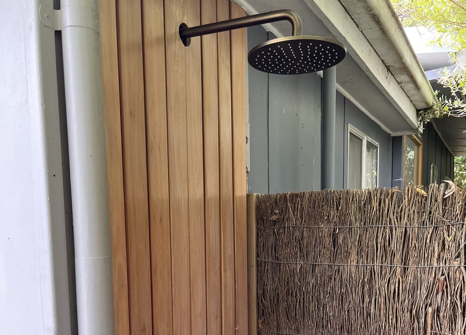 Modern outdoor shower with hot/cold water in private corner off deck