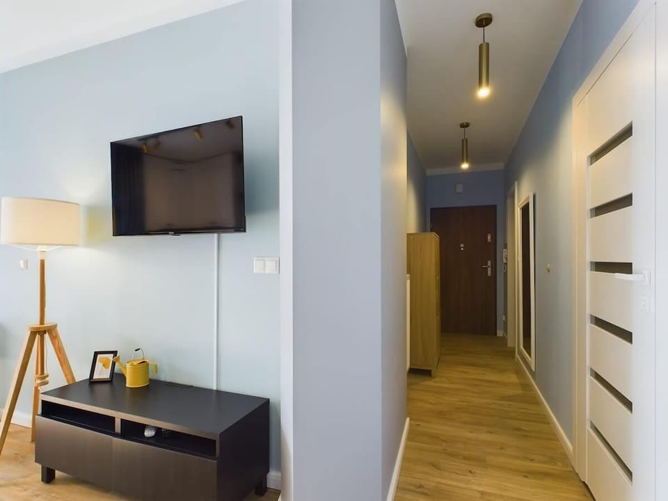  A stylish hallway, elegant doors, and bright flooring offers a welcoming entrance to the apartment.
