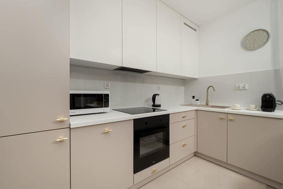 Modern, functional kitchenette with bright cabinets, built-in oven, and elegant countertop, perfect for meal preparation during your stay.