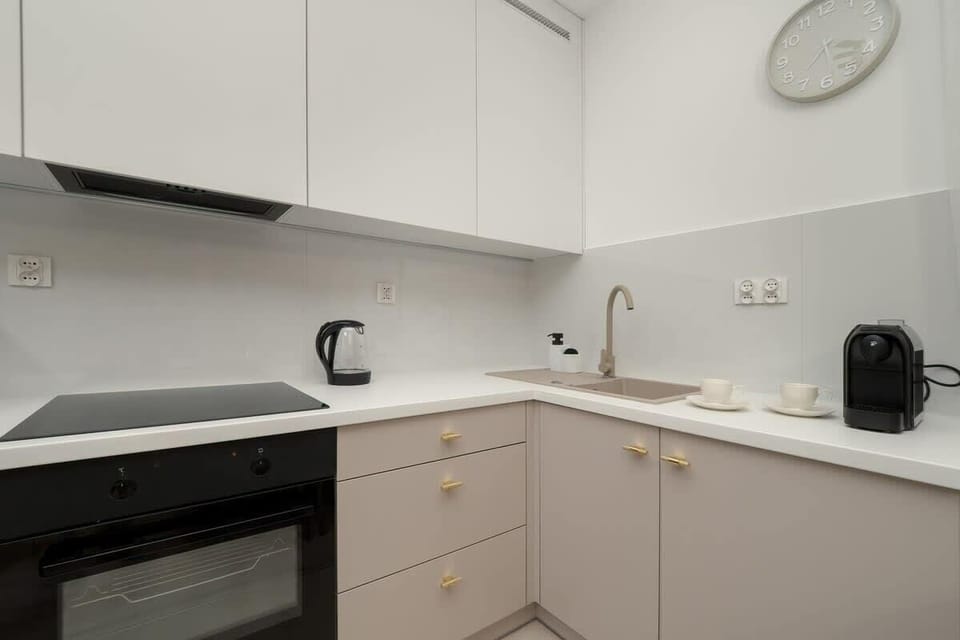Functional kitchenette with white and beige cabinets, minimalist design, and modern appliances, ready for everyday use.